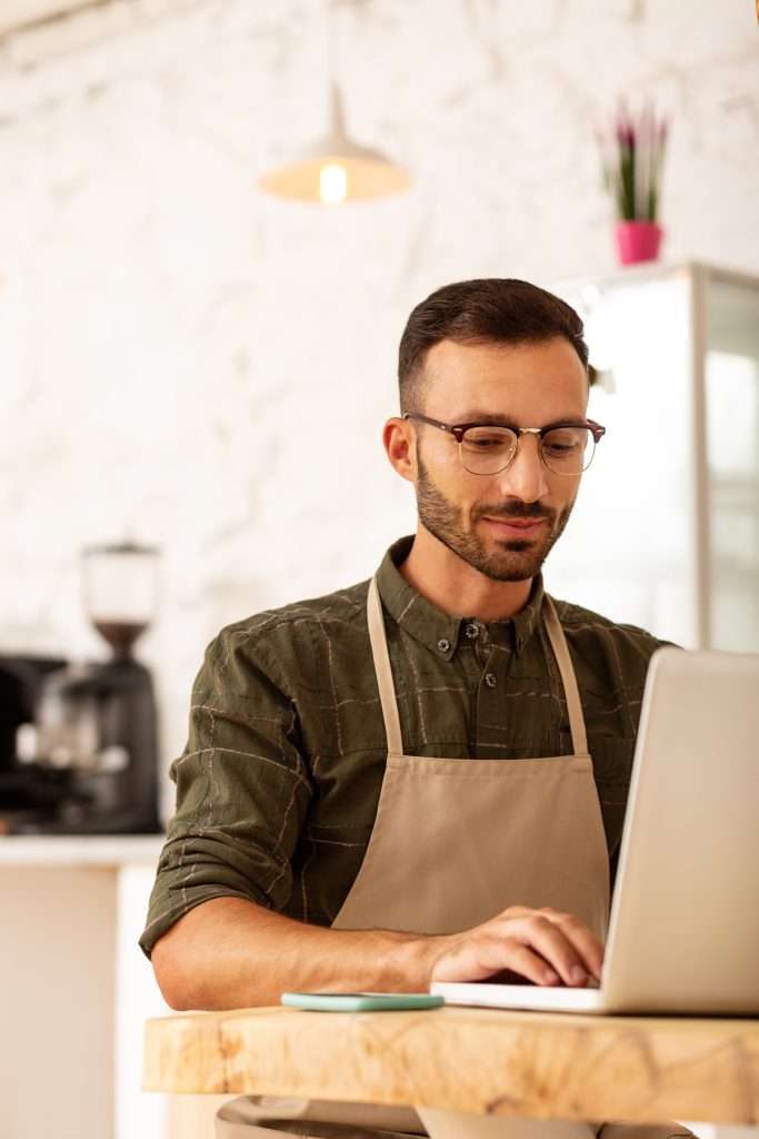 A business owner working on a laptop at the start of a long day